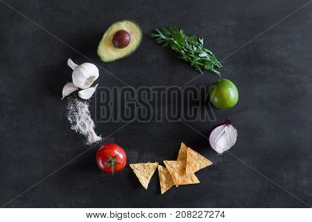 Guacamole ingredients on the black chalkboard. Top view