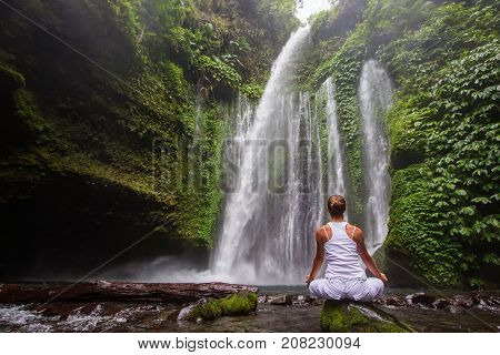 Woman Meditating Doing Yoga Between Waterfalls