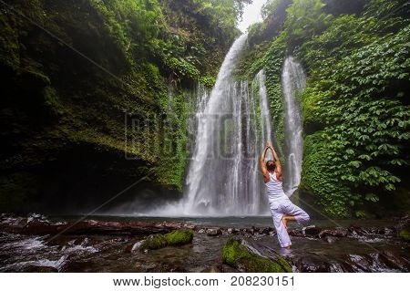 Woman Meditating Doing Yoga Between Waterfalls