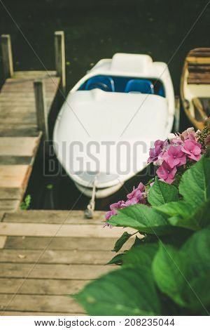 Rent Boat anchored at the pier of a lake in city park. Hamburg.