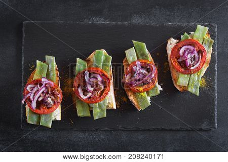 Summer sandwich prepared with fried red onion, tomato and kidney beans. Top view