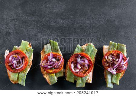 Summer sandwich prepared with fried red onion, tomato and kidney beans. Top view
