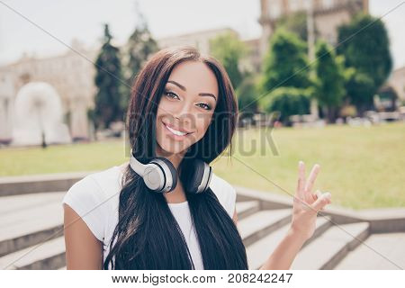 Adorable Afro Lady With Bronze Skin Is In Sunny Town On Stroll, In White T Shirt, With Long Dark Hai
