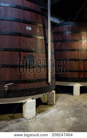 Big old wooden barrel for wine in wine cellar, Wooden vessel on alcohol, Old container port wine, Symbol wine cellar