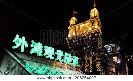 Shanghai, China - Nov 4, 2016: The Bund Tourist Tunnel (Chinese) entrance/exit by night. North China Daily News (AIA - American Insurance Association) building at back. On Zhongshan East 1st Road.