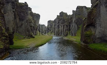 flying through the drone through the canyon Fjarrgljfur and the river going inside it on a sunny day in southern Iceland