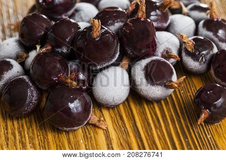 covered with frost and partly melted frost on the black currant of quick freezing. photo close-up, small depth of field