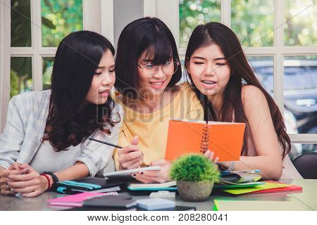 University students sitting together at table with books.Happy young people doing group study.