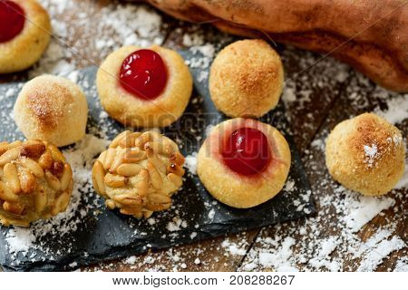 closeup of some panellets, typical confection eaten in All Saints Day in Catalonia, Spain, and a sweet potato on a rustic kitchen table