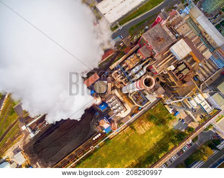 Aerial view to smoking chimmney from lignite power plant. Air pollution and climate change theme. Heavy industry from above. 