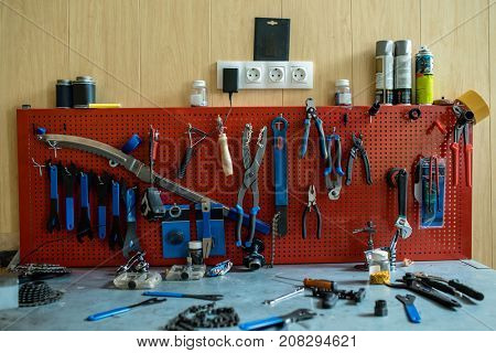 Repair toolkit with handtools hanging on wall and on table near by