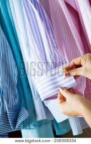 A Woman Picks Up A Man Cufflinks For The Shirt. Choosing Cufflinks.