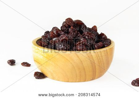 black raisins isolated on white and wooden background