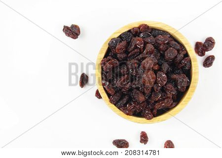 black raisins isolated on white and wooden background