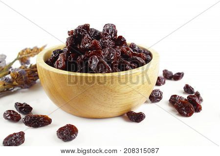 black raisins isolated on white and wooden background