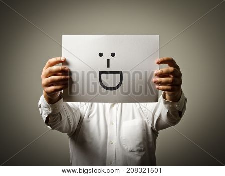 Man is holding white paper with smile. Laughing and smiling concept.