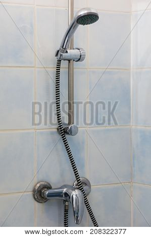 Bathroom sanitary objects details concept. Metal steel silver handshower under shower place