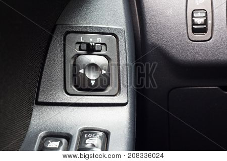 Car Mirror Control Button in car inerier background.