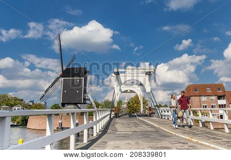 LEIDEN, NETHERLANDS - SEPTEMBER 03, 2017: Young couple on a historic bridge over the canals of Leiden Netherlands