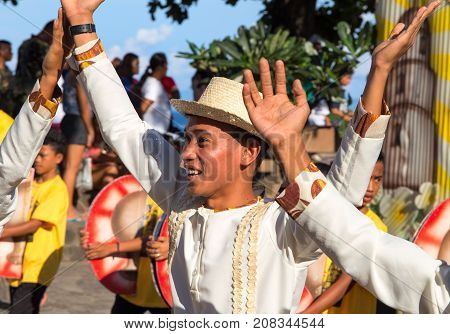Dumaguete Philippines - 16 September 2017: Sandurot Festival dancer in grass hat. Carnival actor dancing in colorful costumes. Sunny day parade in Philippines. Autumn harvest celebration