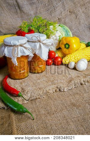 jars with winter supplies, banks with salad are on the table with vegetables