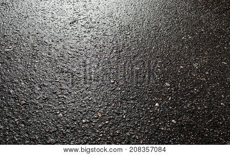 Wet asphalt road after the rain. Asphalt background. Asphalt perspective. Background and texture. Sun reflection