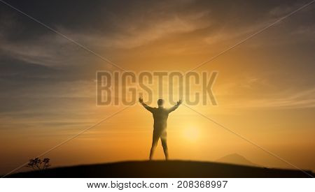 uccessful concept Silhouette man stand on the top of mountain and look through the sunrise sunset and give two hand up to feel like a winner success finishreach a goal of live jobswork