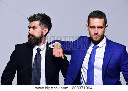 Executives present partnership friendship and strength. Business confidence and teamwork concept. Businessmen with confident faces in formal suits on grey background. Leaders rely on each other