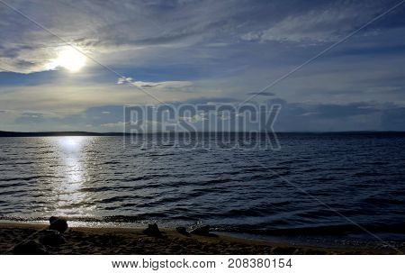 hazy sun over the lake shines through the gray clouds, South Ural, Uvildy