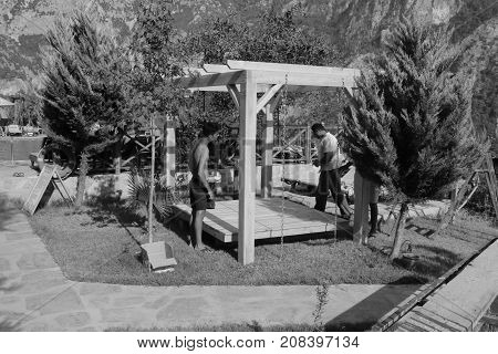 20TH JULY 2017, KABAK,TURKEY: Turkish workmen building a swing seat pergola in an olive garden at kabak, turkey, 20th july 2017