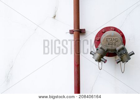 Standpipe on the white wall,a vertical pipe extending from a water supply, especially one connecting a temporary tap to the main.