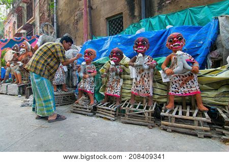 KUMARTULI KOLKATA INDIA - OCTOBER 10 2014 - Artist preparing clay idols of female demons to be used during Kali Puja worshipping of Goddess Kali Hindu festival of Deepavali or Diwali.