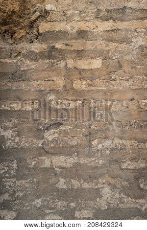 Old brick wall with cracks and scratches. Brick wall background. Distressed wall with broken bricks texture. House facade