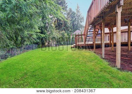 Backyard View Of Grey Rambler House With Upper And Lower Decks