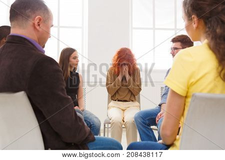 Meeting of support group. Young despaired woman crying during rehab group therapy. Psychotherapy, depression, life issues concept