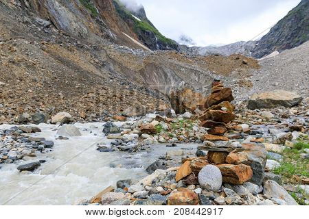 pyramids of stones in the valley river near Chalaadi glacier in Caucasus mountains in summer in Georgia