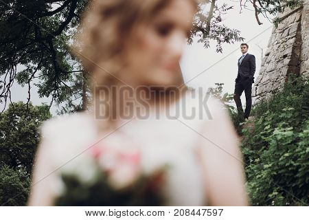 Beautiful Gorgeous Bride And Groom Posing Outdoors. Happy Wedding Couple Embracing At Old Castle. Ha