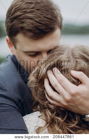 Groom Embracing And Hugging Beautiful Gorgeous Bride. Happy Sensual Wedding Couple In Love, Atmosphe