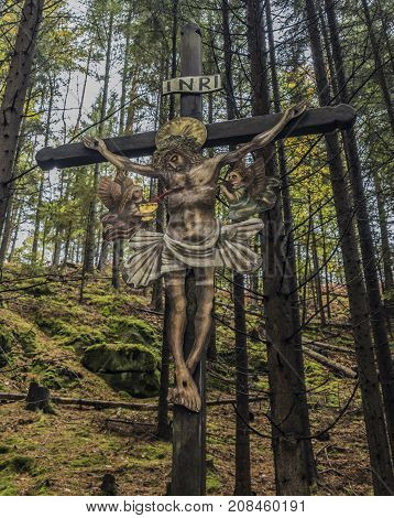 Jesus on crucifix in forest in national park Ceske Svycarsko