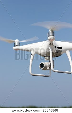 KAGAWA, JAPAN - OCTOBER 10, 2017: White remote controlled Drone Dji Phantom4 Pro equipped with high resolution video camera flying in air and blue sky in the background