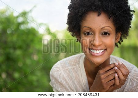 Happy confident African American woman smiling outside.