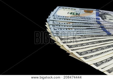 Stack of one hundred dollar bills. Stack of cash money in hundred dollar banknotes. Heap of hundred dollar bills isolated on black background