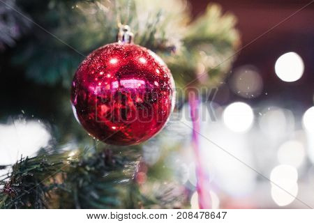 Beautiful red color christmas decorations hanging on christmas tree with shiny glare