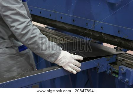 operator bending metal sheet by sheet bending machine, production work process in fabricated factory by worker, manual or semi auto processing.