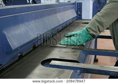 operator bending metal sheet by sheet bending machine, production work process in fabricated factory by worker, manual or semi auto processing.
