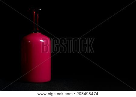 Red glass bottle on a dark background. Beautiful combination red and black.