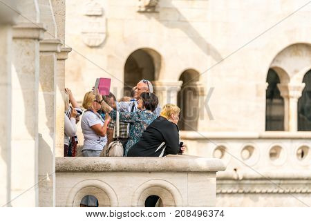 A balcony viewpoint in Budapest near Matthias Church with a small group of people looking at the view and taking selfie pictures.
Budapest Hungary - September 27 2017: Daytime side view of a small group of caucasian male and females standing at a viewpoin