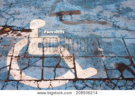 Abstract health sign on with handicapped people symbol pictogam on old pavement background. Health care concept