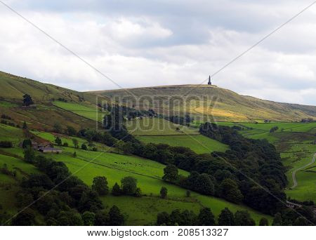stoodley pike monument in west yorkshire landscape with upland farms and moors in the distance