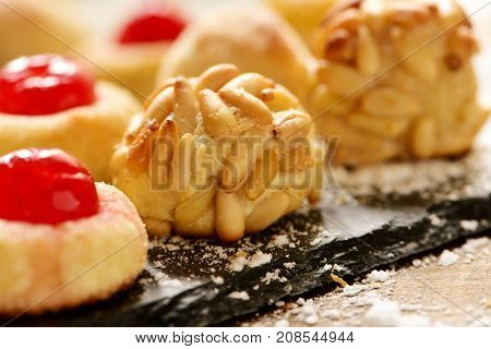 closeup of some panellets, typical confection eaten in All Saints Day in Catalonia, Spain, on a wooden table
